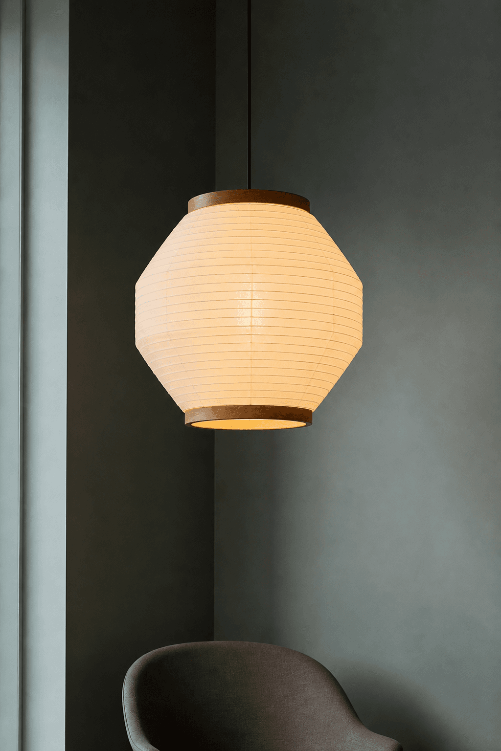 Paper and oak pendant lamp glowing in a tall room